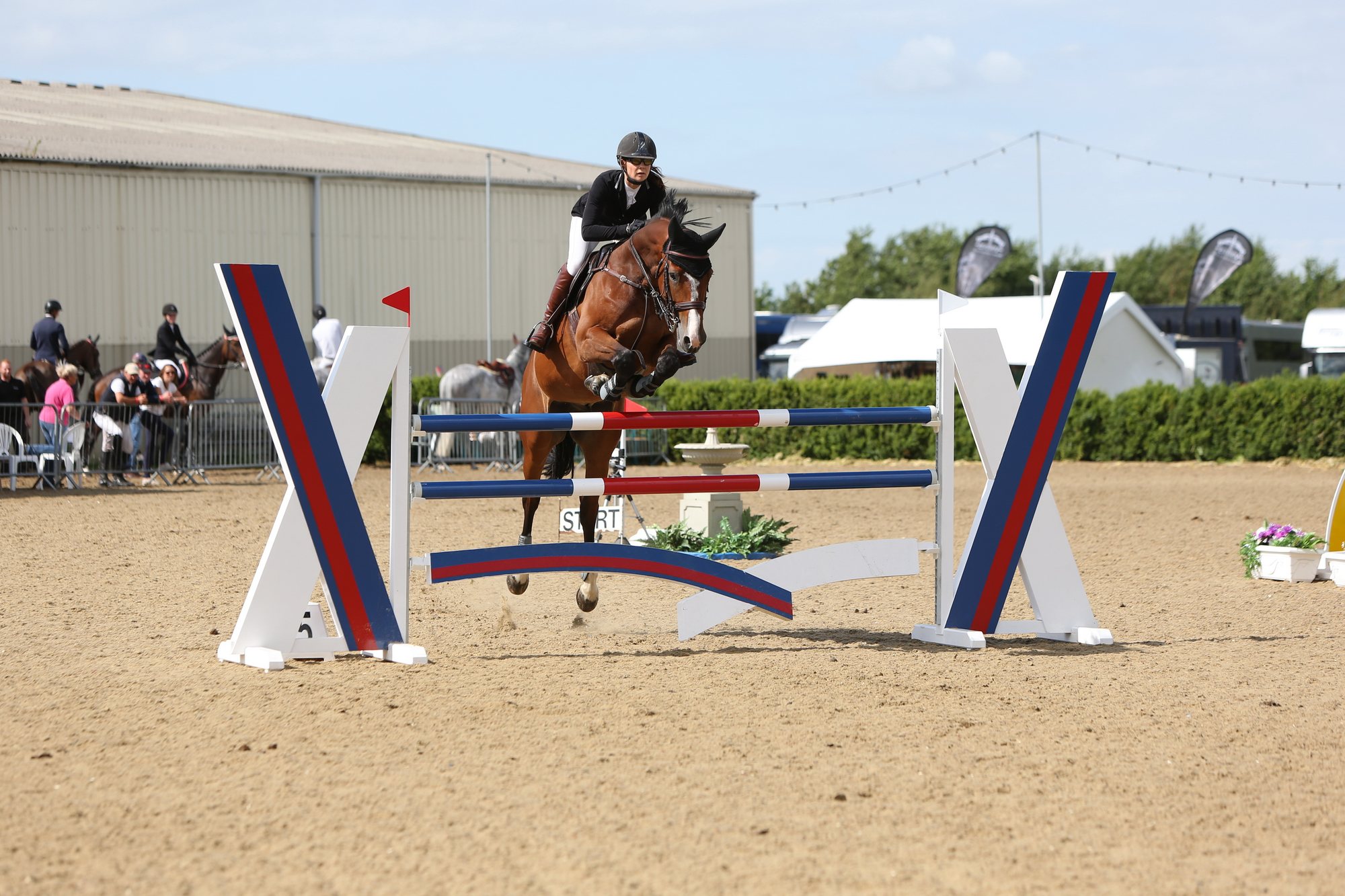Jumping a red, white and blue oxer at an away show