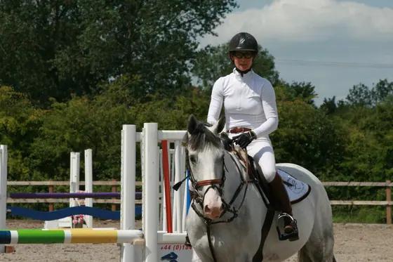 A rider on a grey in the arena