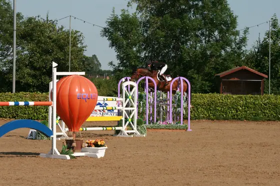 A bay jumping beside an orange balloon filler, butterfly wings behind